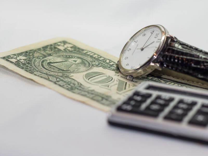 Watch, dollar bill and calculator